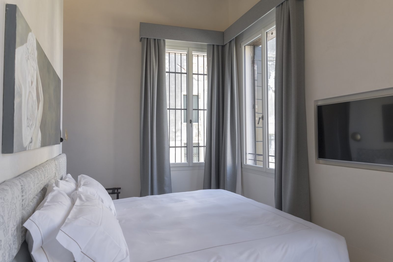 camera-letto-quadro-appartamento-coriandolo-grigio-bianco-finestre-tv-schermo-venezia-palazzo-morosini